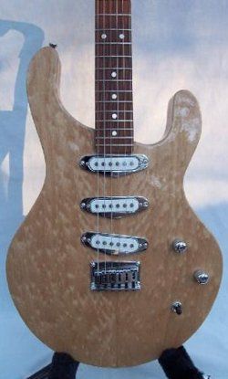 A guitar is sitting on a stand with a chair in the background