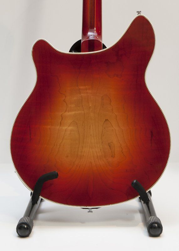 The back of a red guitar on a stand