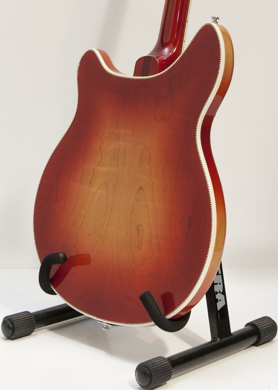 A red guitar is sitting on a guitar stand