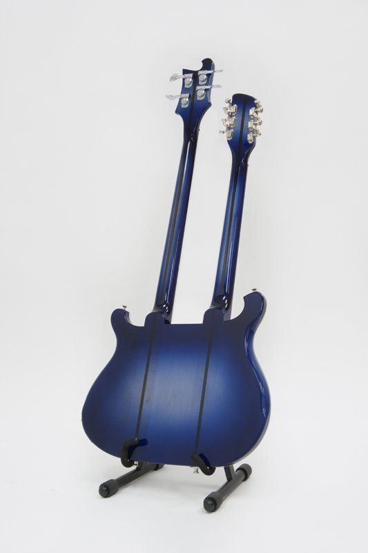 A blue double neck guitar is sitting on a stand.