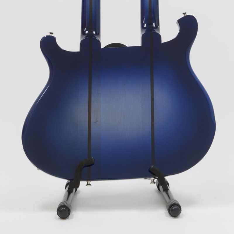A blue double neck guitar is sitting on a stand