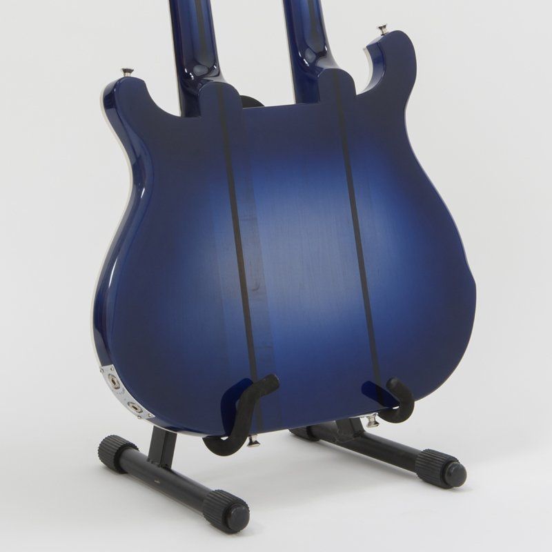 A blue double neck guitar is sitting on a stand