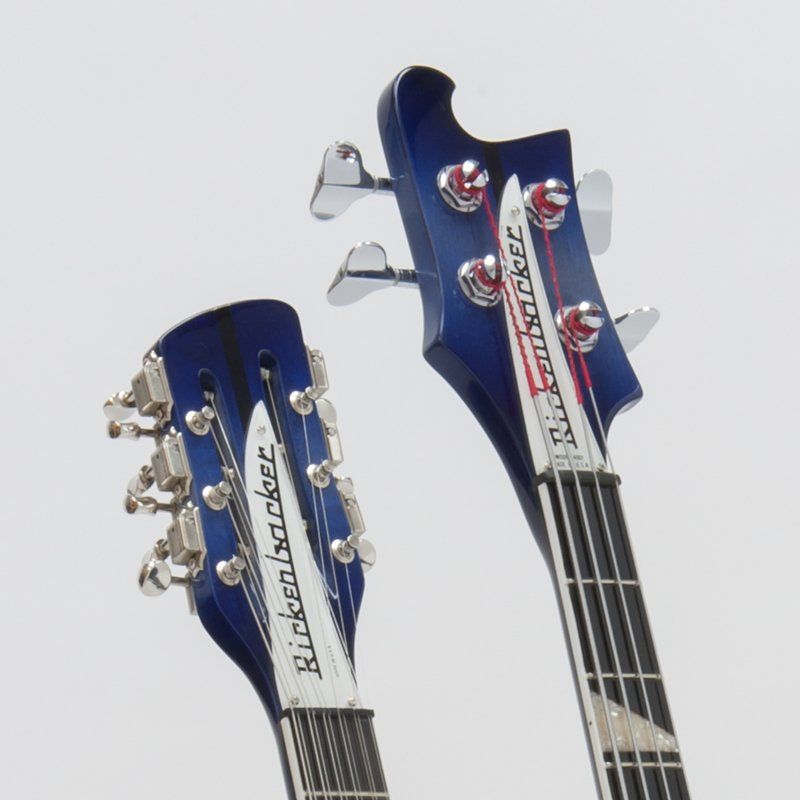 Two rickenbacker guitars are sitting next to each other