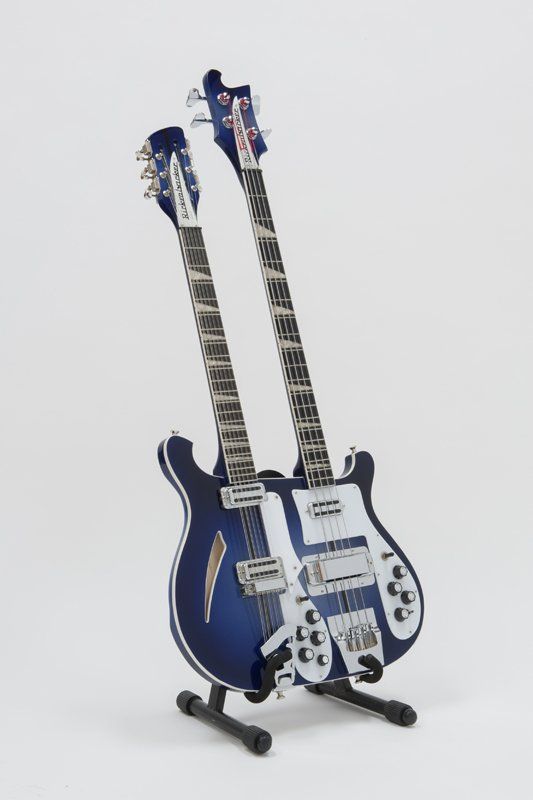 A blue double neck guitar is sitting on a stand