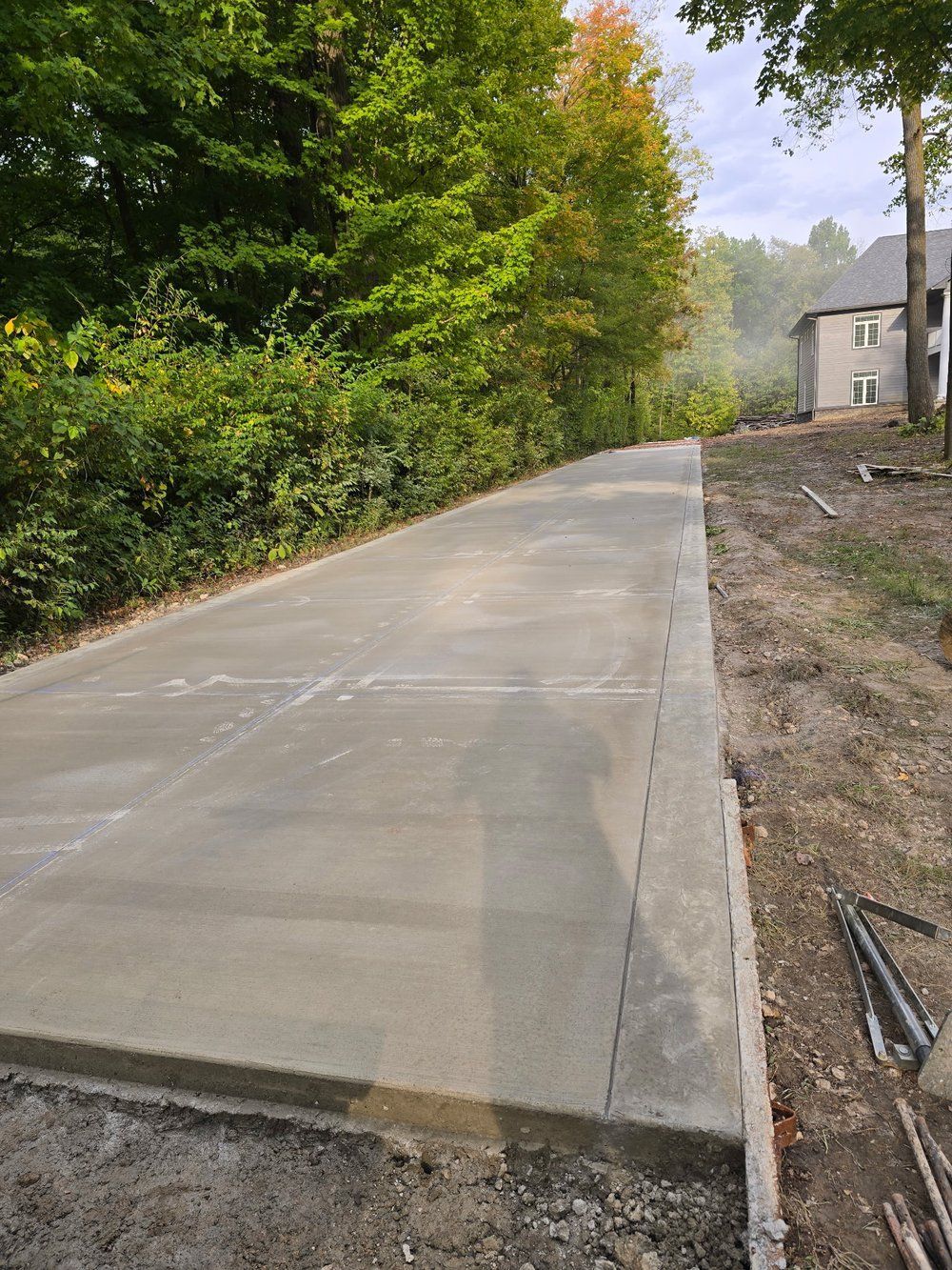 A concrete driveway is being built in front of a house.