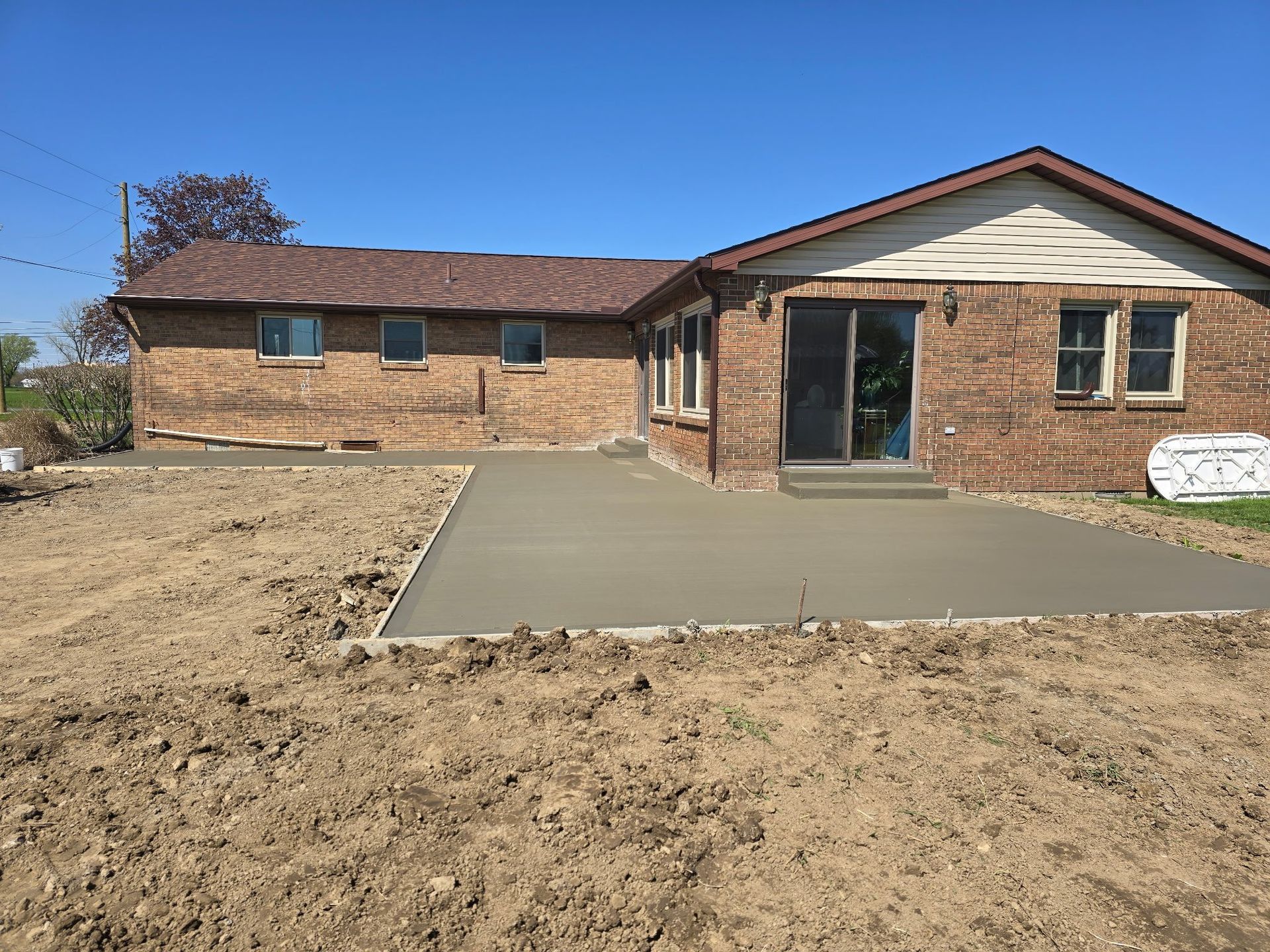 A brick house with a concrete driveway in front of it