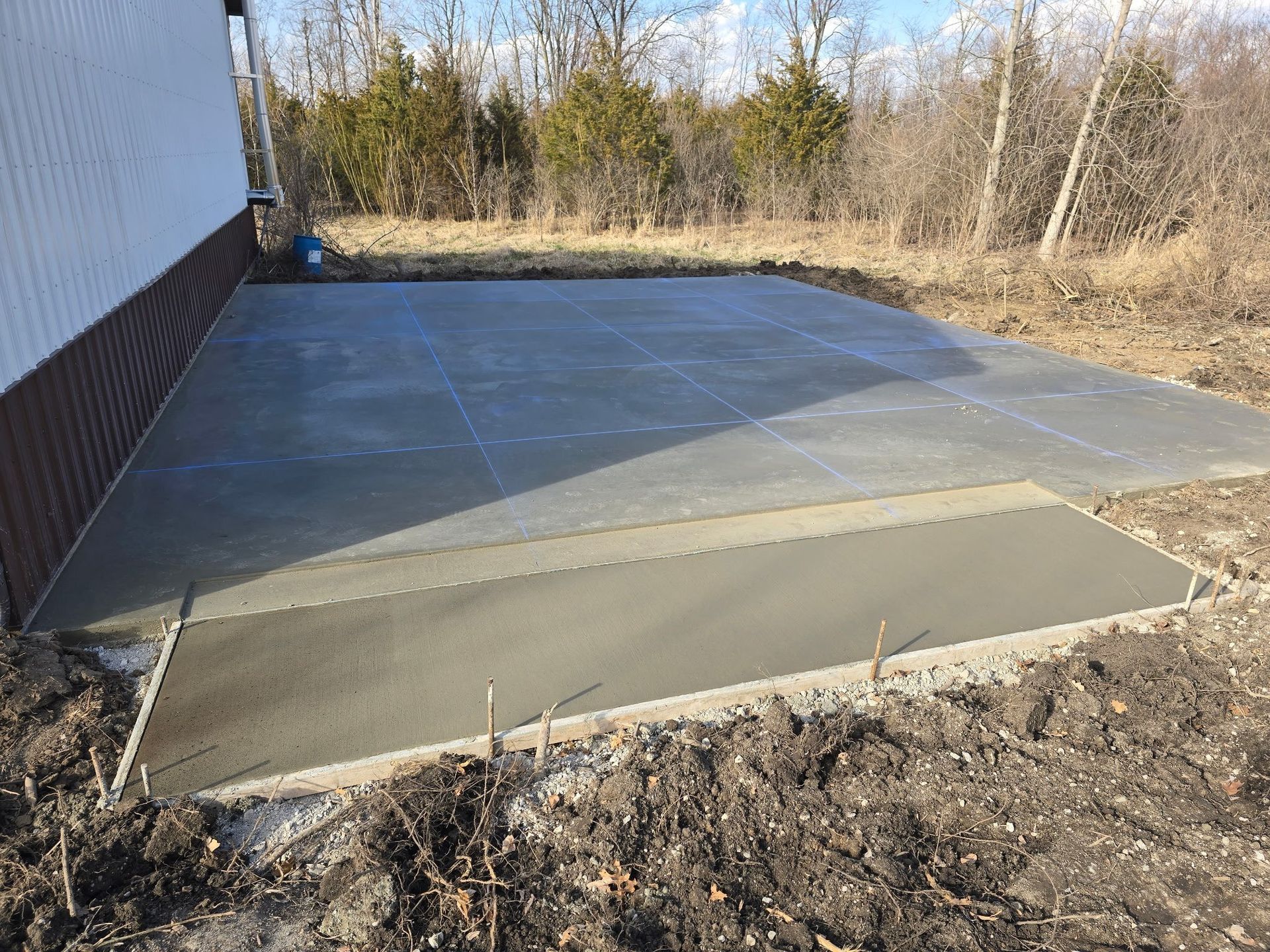 A concrete driveway is being built in front of a house.