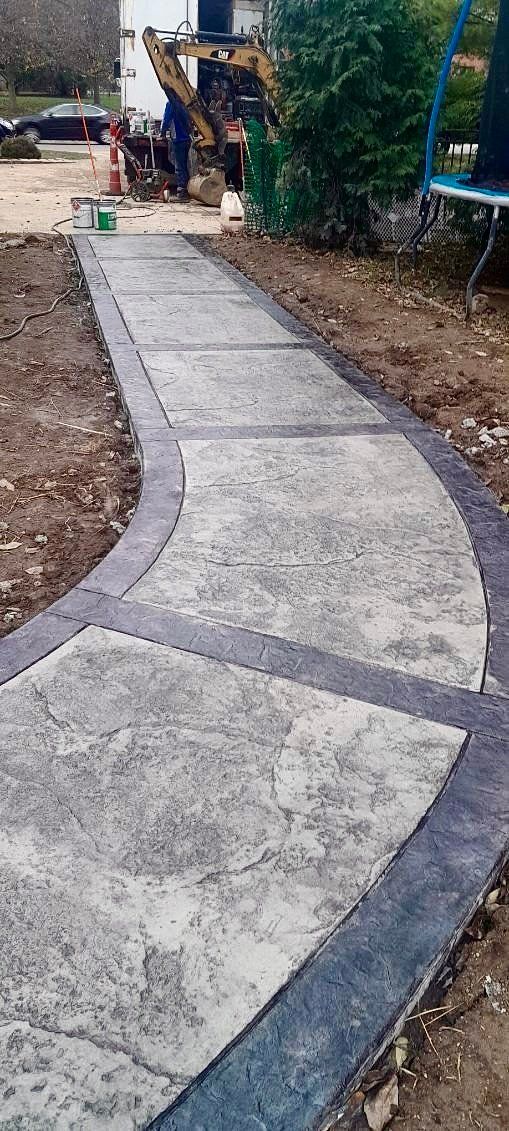 A concrete walkway is being built in a yard.