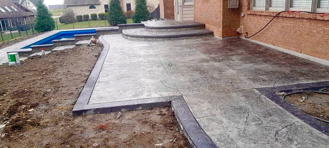 A concrete walkway is being built in front of a house.