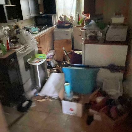 A kitchen filled with lots of junk and boxes.