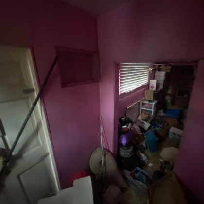 A room with pink walls and a window with blinds.