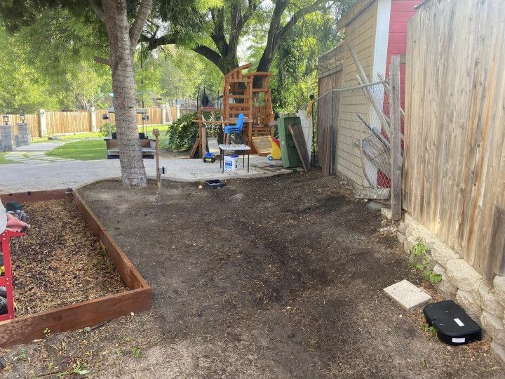 A backyard with a wooden fence and a playground