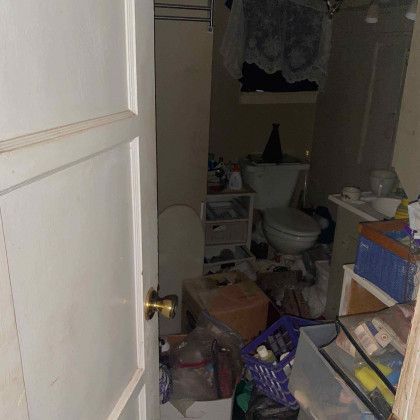 A bathroom with a toilet, sink, and trash can.