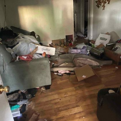 A living room filled with lots of junk and a couch.