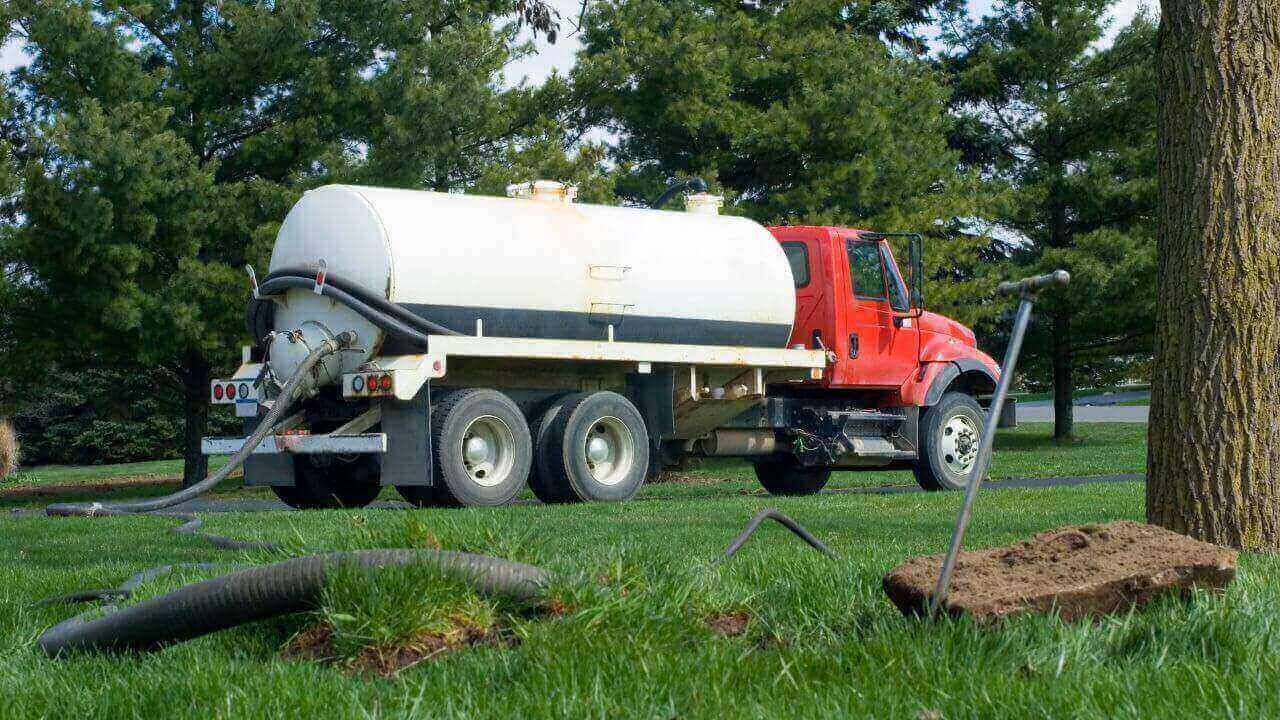 Image of septic tank truck parked in grass.