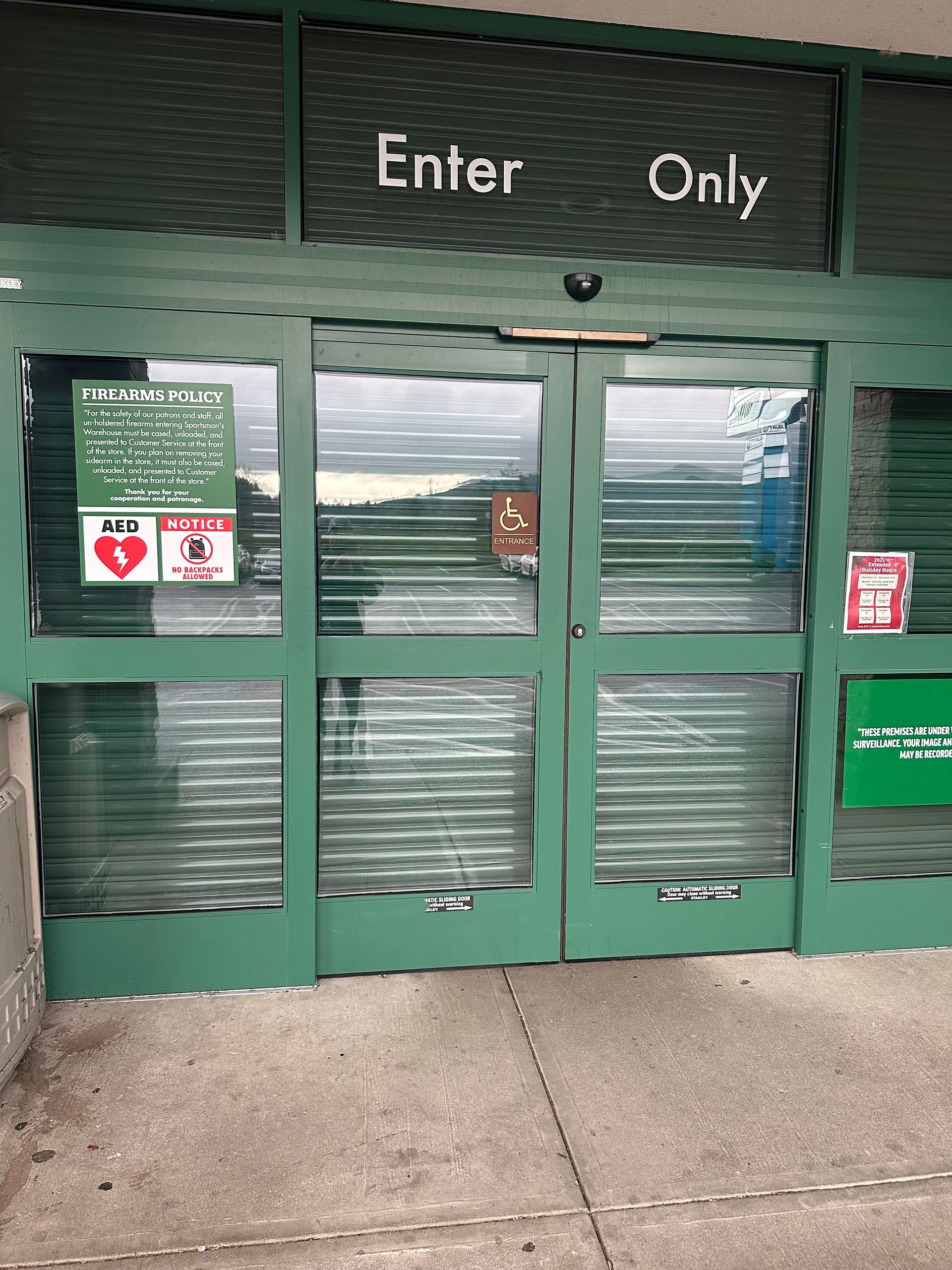 Green commercial sliding doors with plastic strip curtains on service building