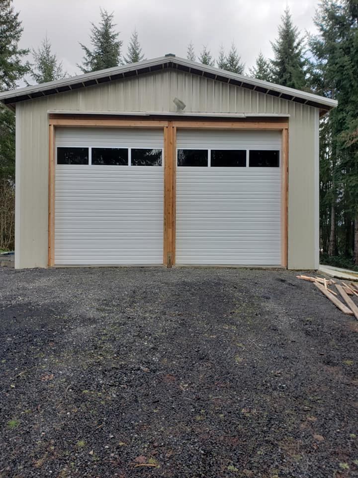Two white garage doors with wood trim on detached garage