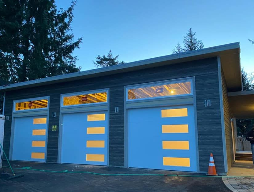 Modern gray garage doors with horizontal window panels on residential garage