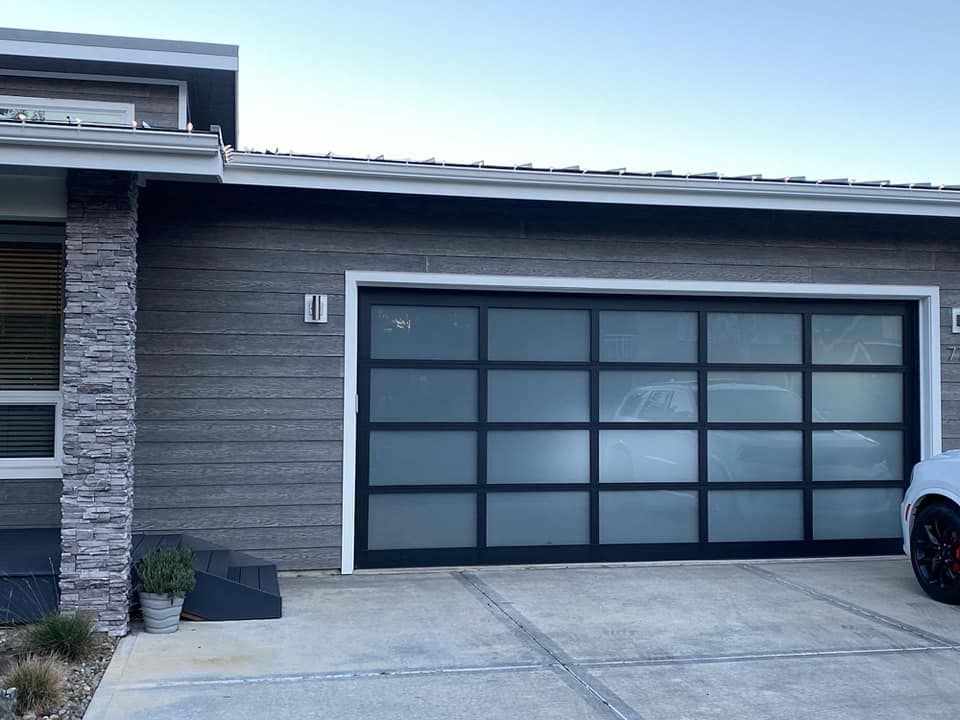 Modern smoked glass double garage door installed by Johnson & Johnson Overhead Door INC in Tumwater, WA