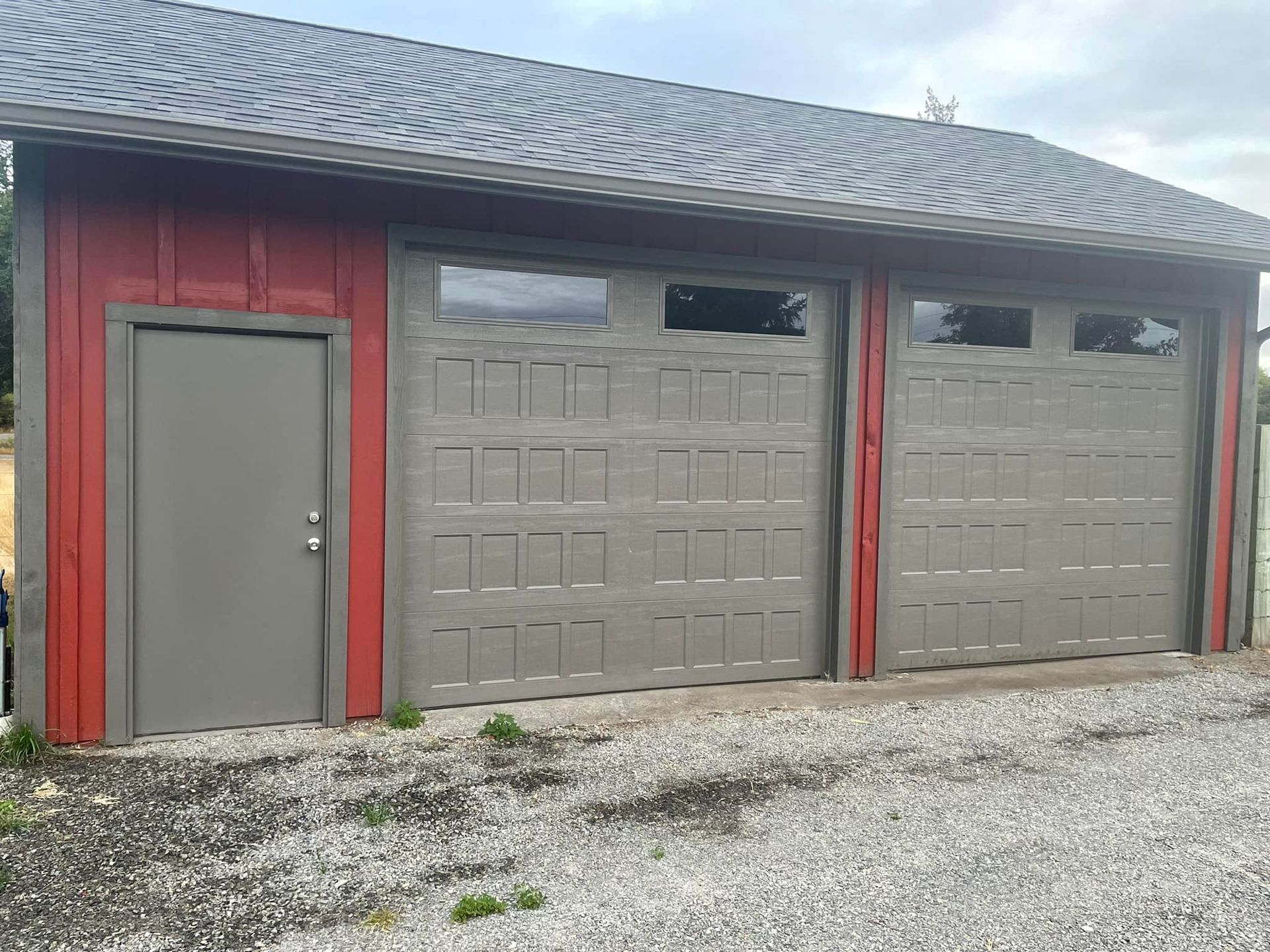 Gray garage doors on residential garage with side entry door