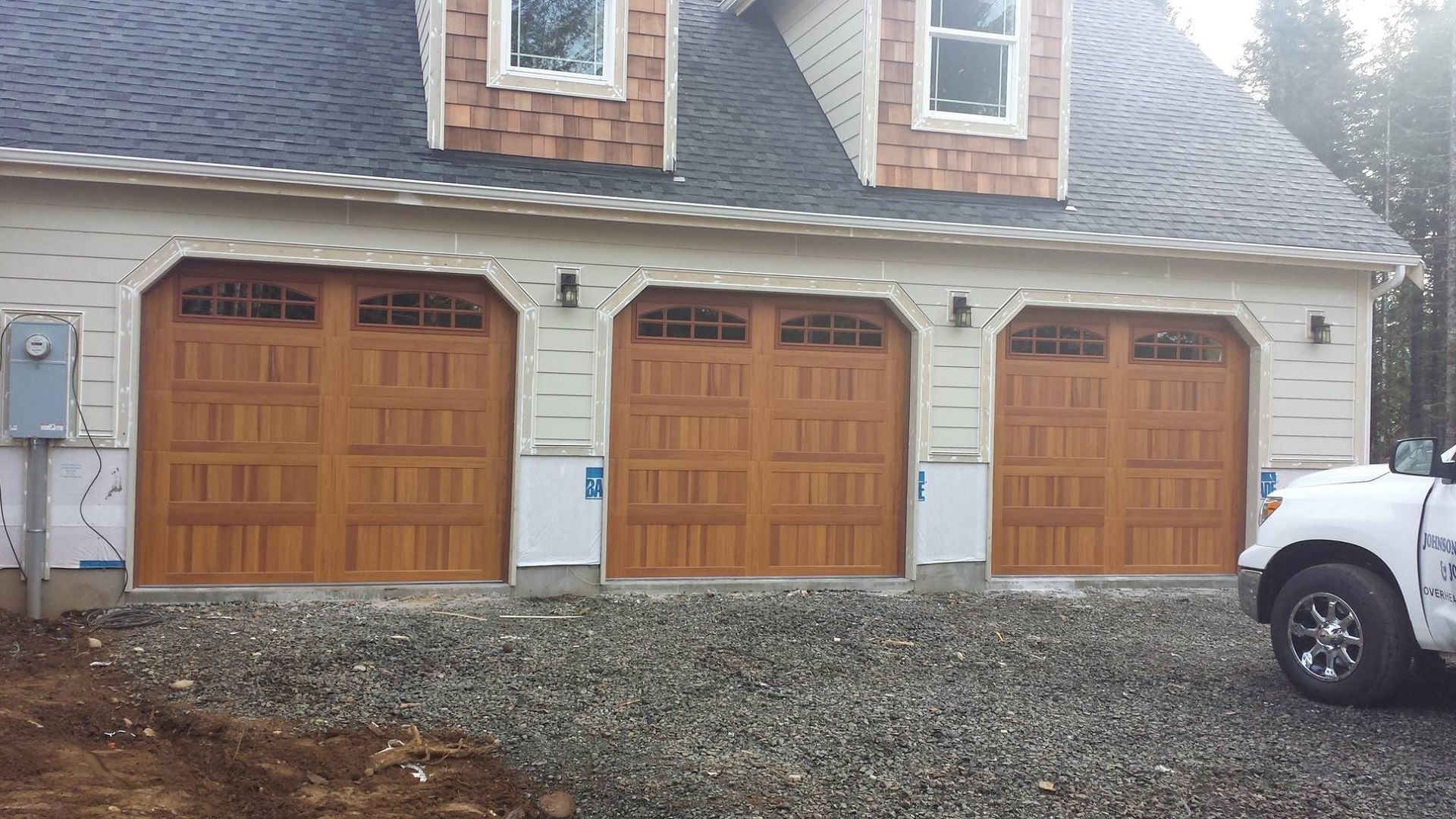 Three wood carriage-style garage doors on residential home