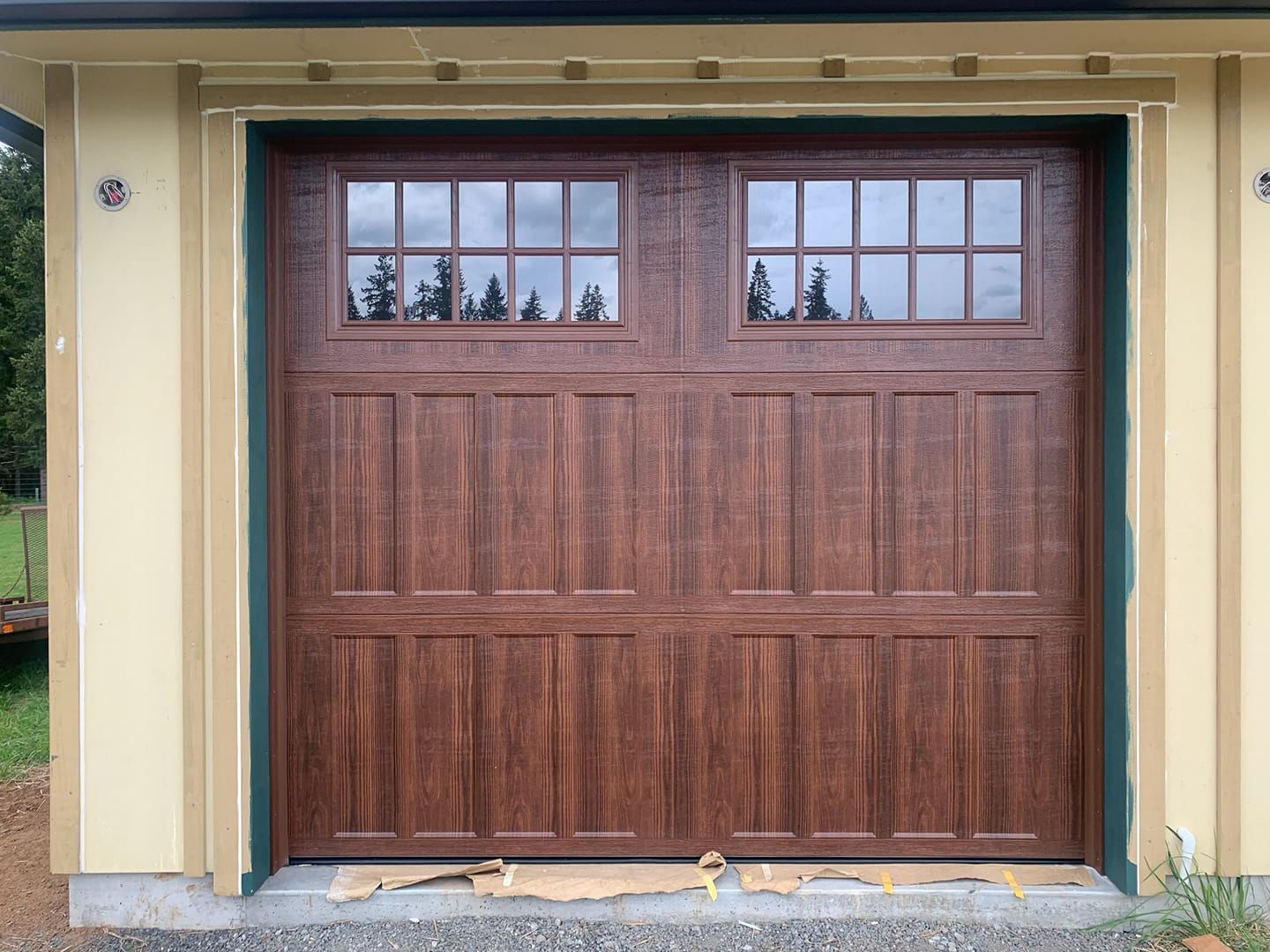 Single wood garage door with window panels on residential garage