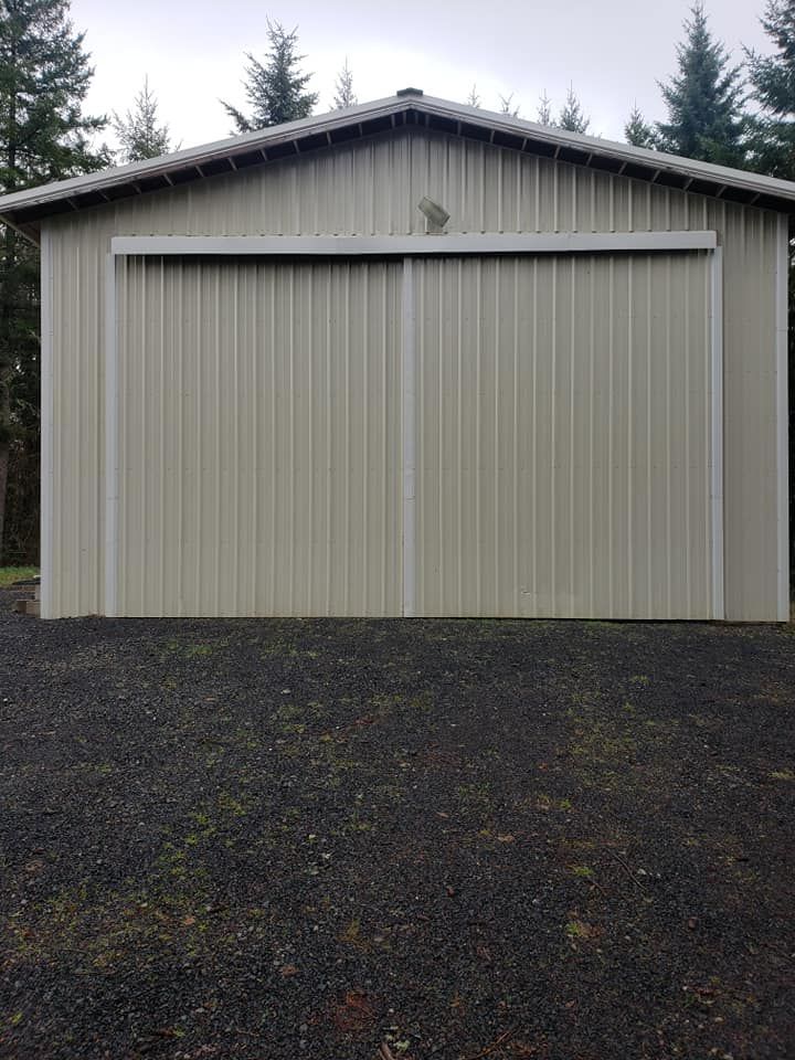 Metal outbuilding with large sliding garage door on residential property