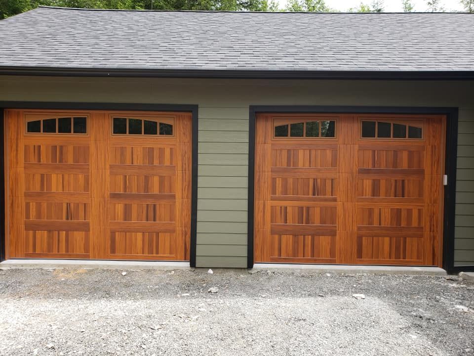 Two wood garage doors on residential garage with green siding