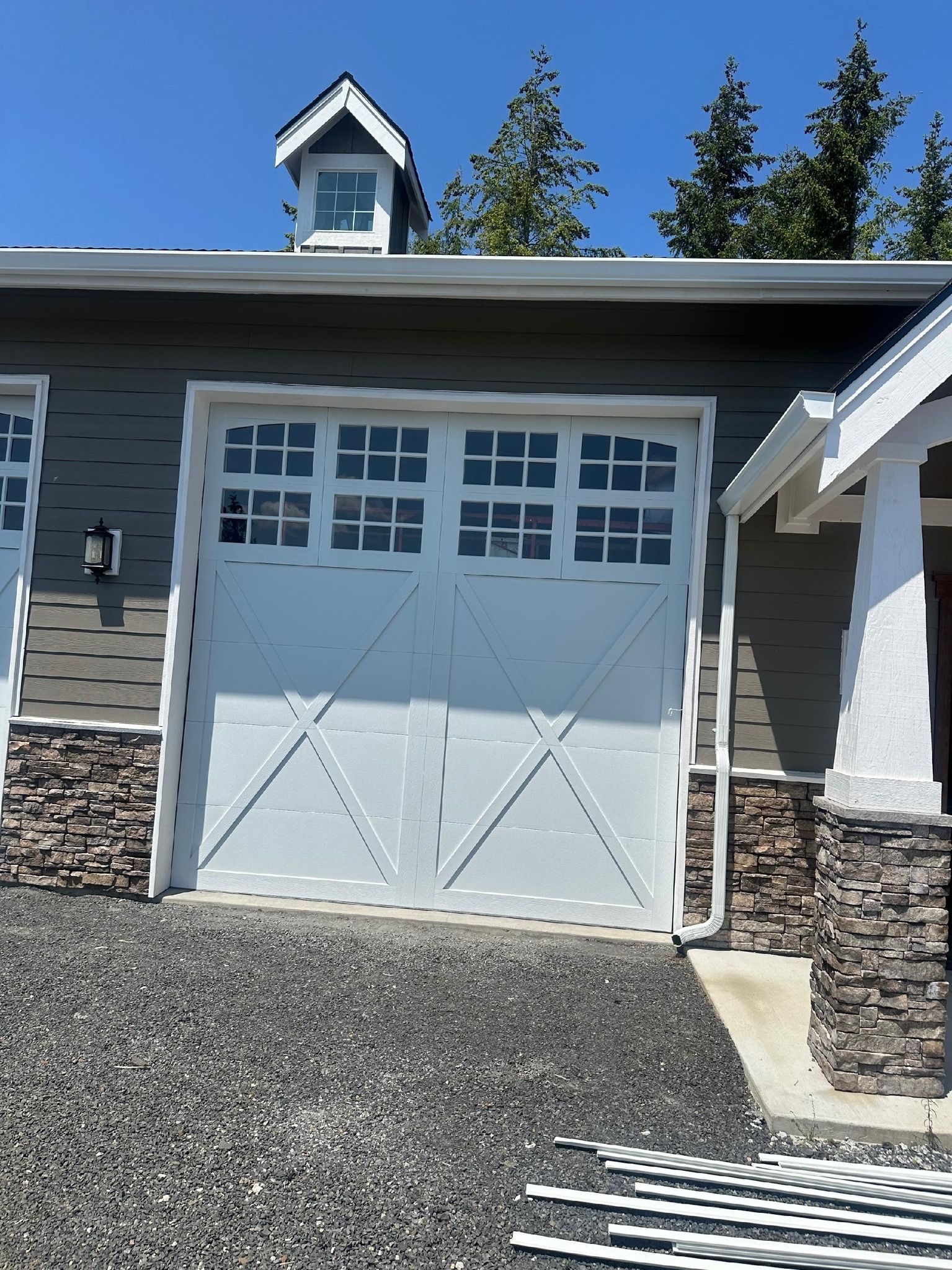 White carriage-style garage door with windows on residential home