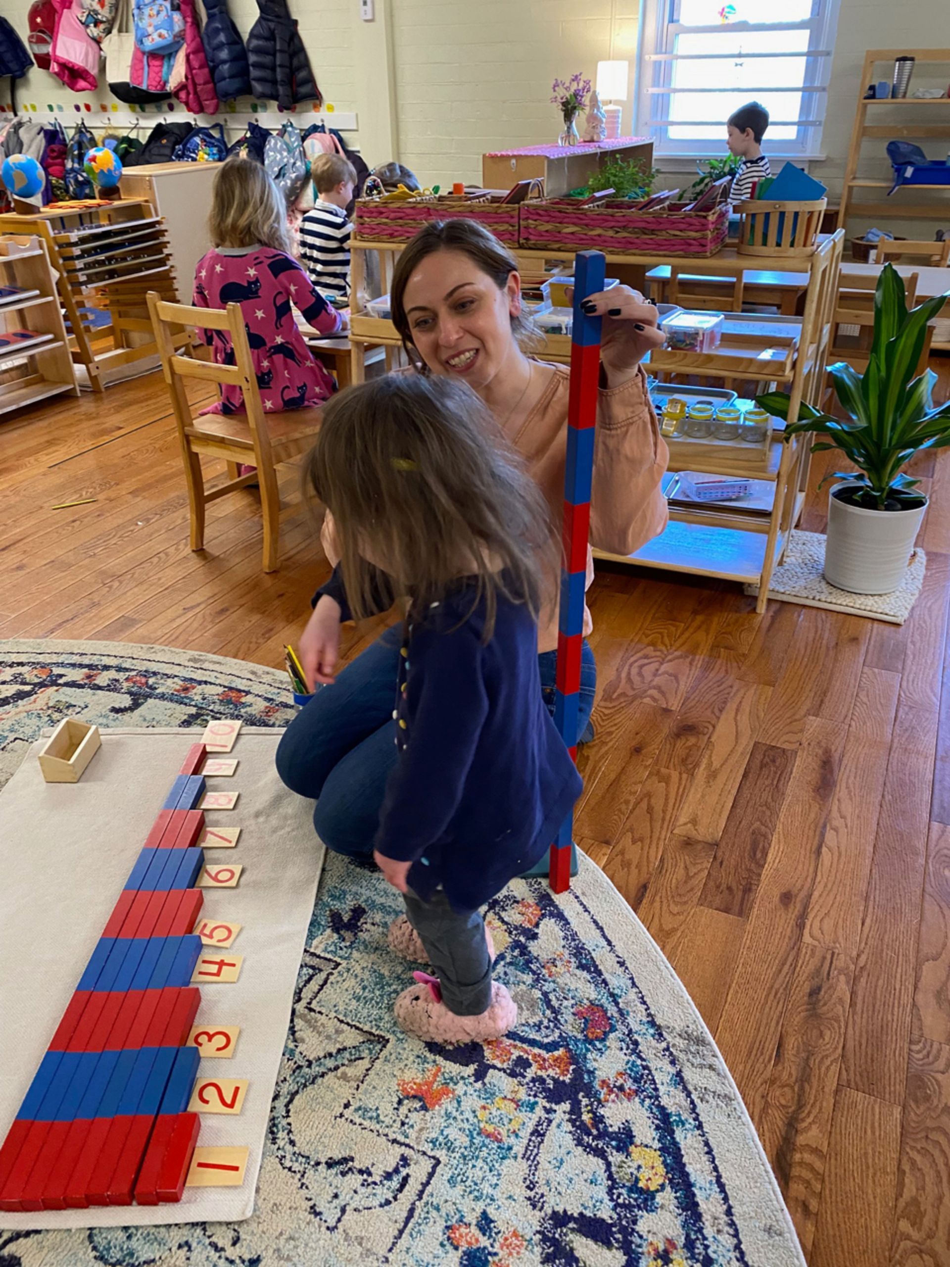 Montessori guide child working in the classroom