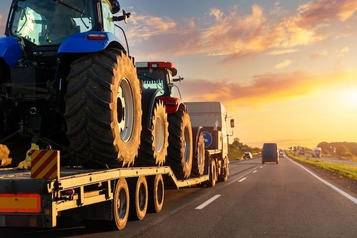 A Tractor is Being Towed by a Semi Truck on a Highway — KBX Mechanical In Mackay, QLD