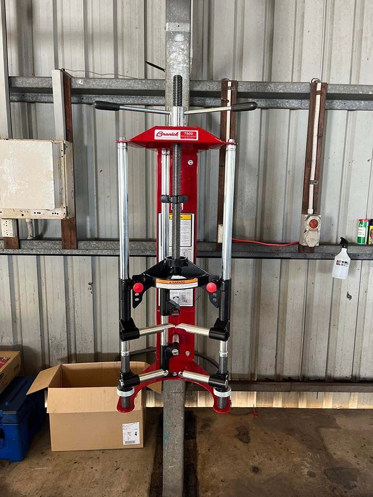 A Red and Silver Machine is Sitting in a Garage Next to a Box — KBX Mechanical In Mackay, QLD
