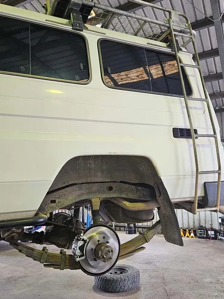 A White Van With A Ladder On Top Of It Is Parked In A Garage — KBX Mechanical In Mackay, QLD