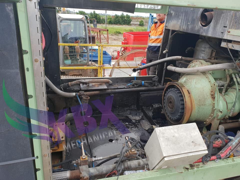 A Man is Working on the Engine of a Machine — KBX Mechanical In Mackay, QLD