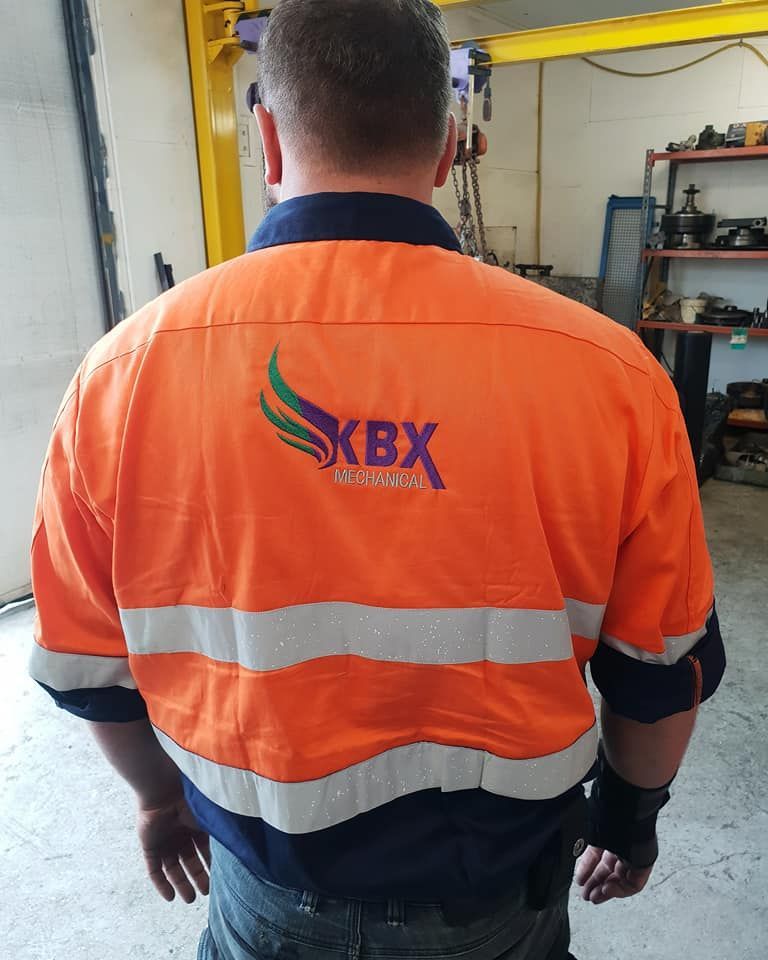 A Man Wearing an Orange Shirt With Kbx Written on the Back — KBX Mechanical In Mackay, QLD