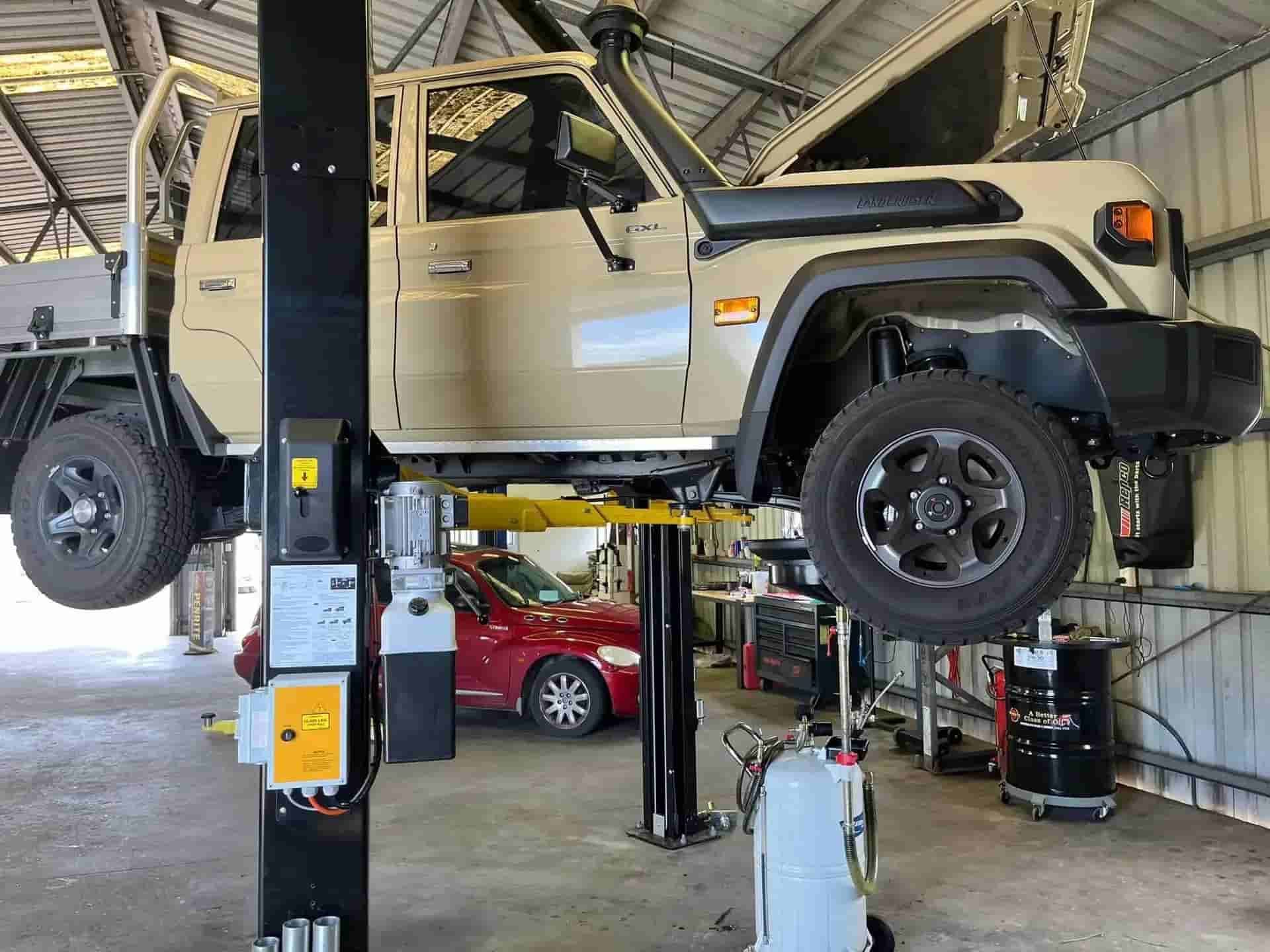 A Car Is Sitting On A Lift In A Garage — KBX Mechanical In Moranbah, QLD