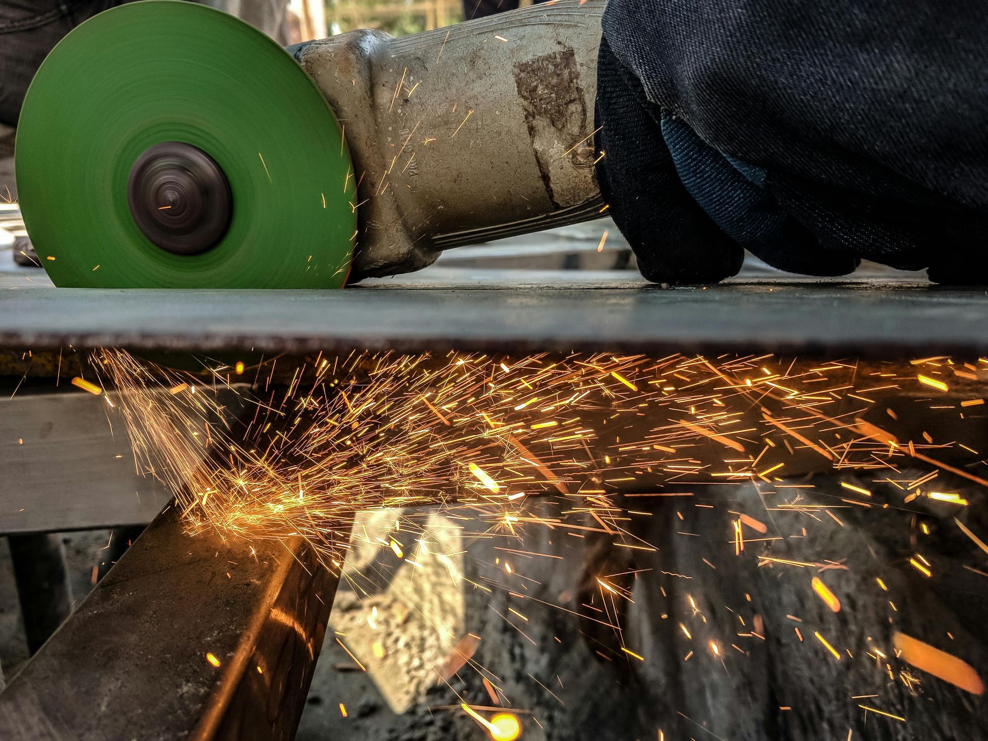 A person is using a grinder to cut a piece of metal. — KBX Mechanical In Moranbah, QLD