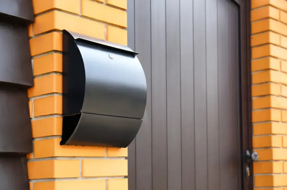 A close-up view of the metal hardware, cable, and roller track of an overhead residential garage door system.