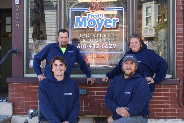 A group of people posing for a picture in front of a store called fredy moyer