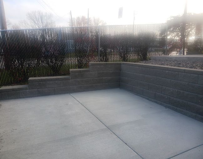 A concrete patio with a fence in the background.