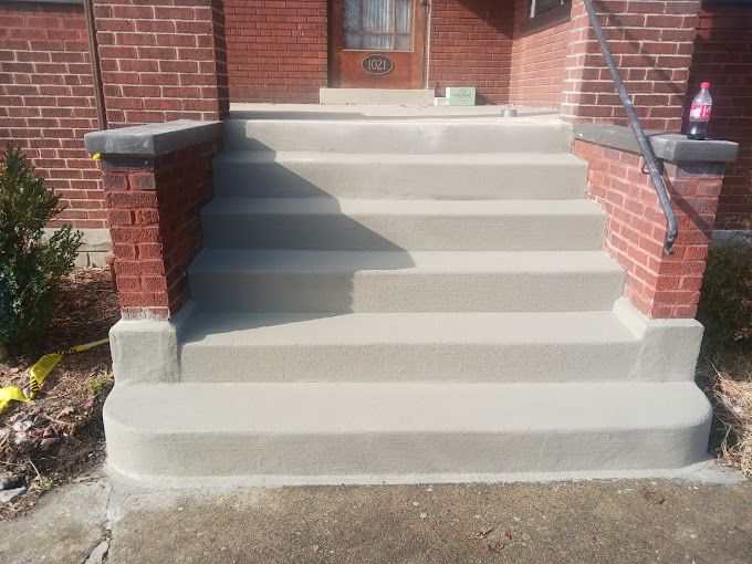 A set of concrete steps leading up to a brick building.