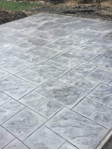 A close up of a concrete driveway with a pattern on it.