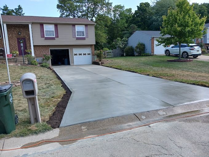 A concrete driveway is being built in front of a house.