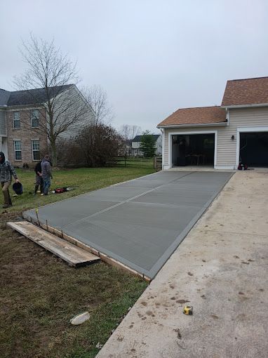 A concrete driveway is being built in front of a house.