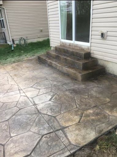 A concrete patio with steps leading to a house.