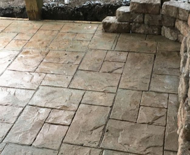 A close up of a brick floor with a brick wall in the background.
