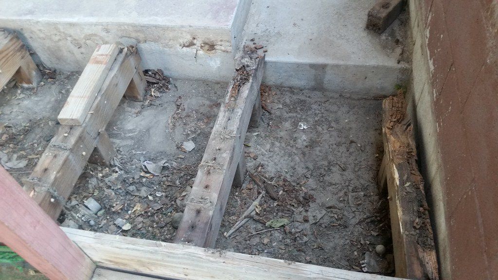 Exposed wooden beams visible from a recently removed deck