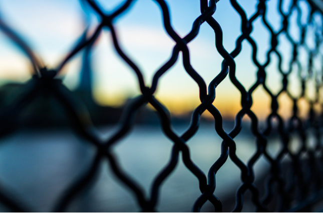 black chain link fence with sunset in the background