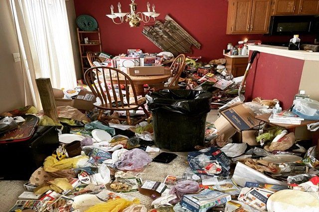 hoarder house full of trash in kitchen with garbage cans and chairs