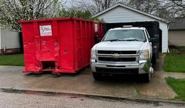 dump truck next to a red dumpster